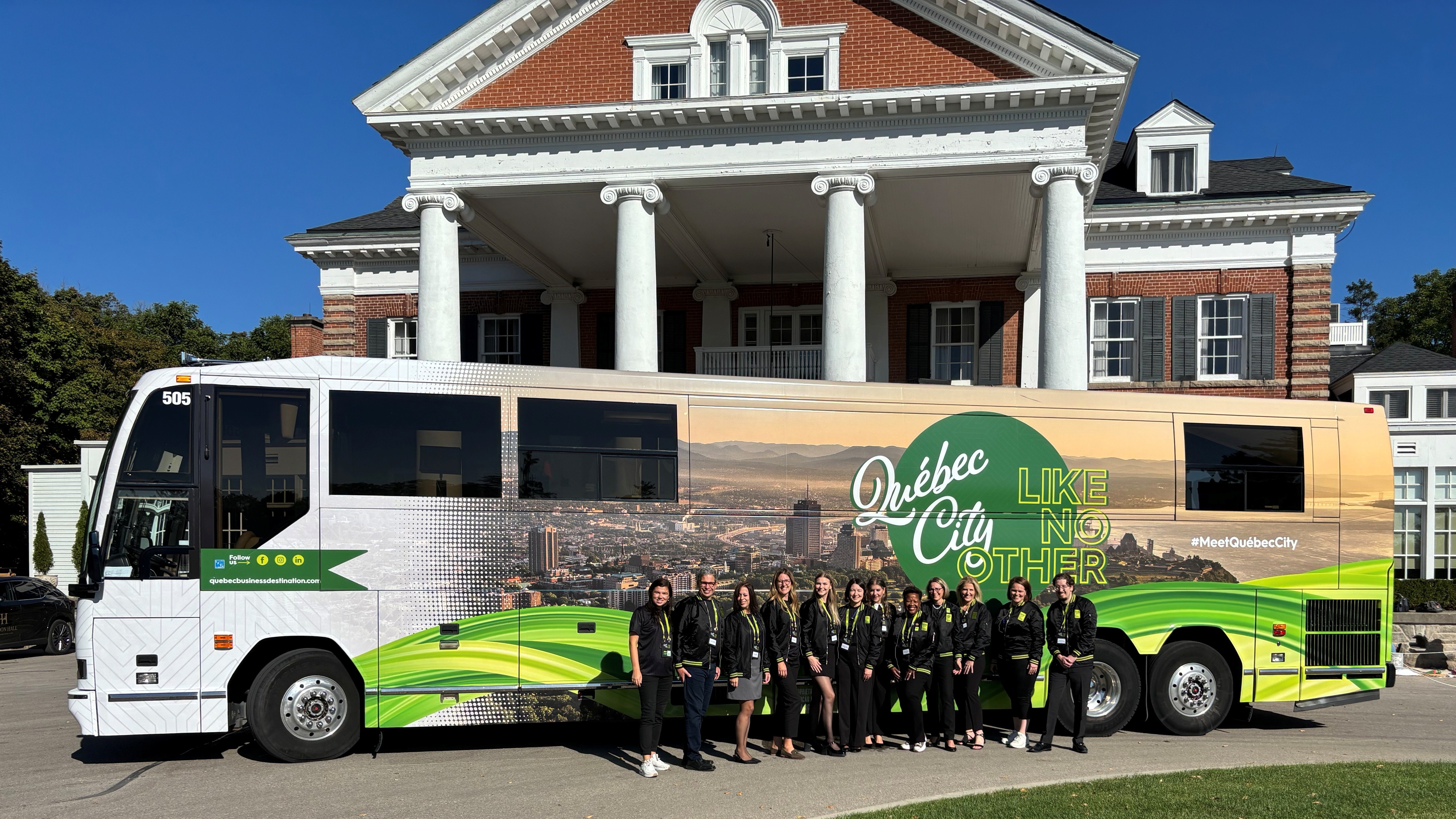 The Québec City Business Destination's team posing in front of their QDa-branded bus before departing from Ottawa on a sunny day.