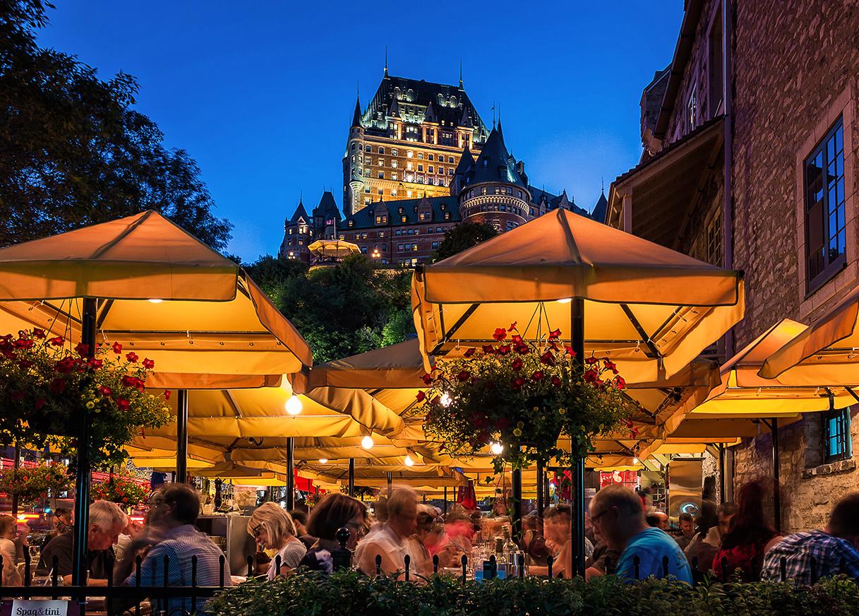 Restaurant terrace overlooking the Fairmont Le Château Frontenac at night in Québec Ctiy