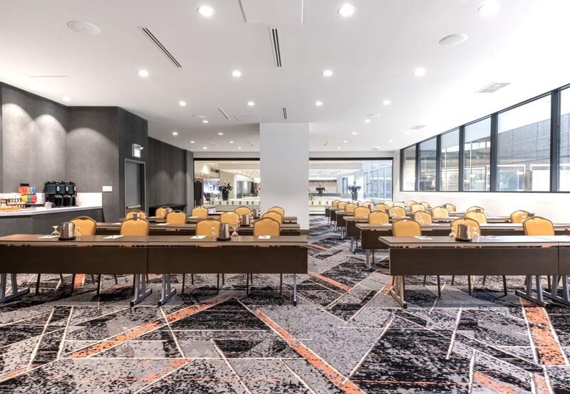 Big conference rooms with multiple tables, yellow chairs, and a patterned carpet.