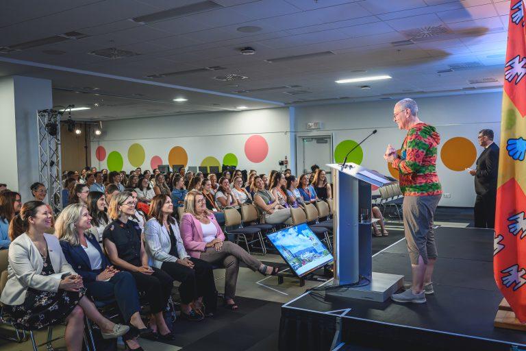 A speaker addresses a full audience during a conference session at the 1st International Congress on Safe Sport Research in Québec City, with participants listening attentively.