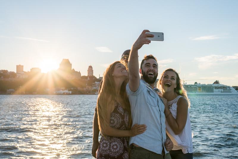 4 personnes qui prennent une photo selfie devant un panorama de Québec