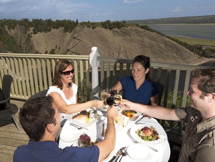 People are eating a meal on the terrace of the Manoir Montmorency, located on the site of the Parc de la Chute-Montmorency.