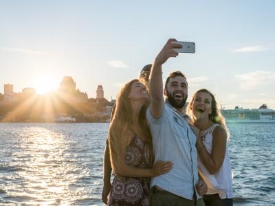 4 personnes qui prennent une photo selfie devant un panorama de Québec