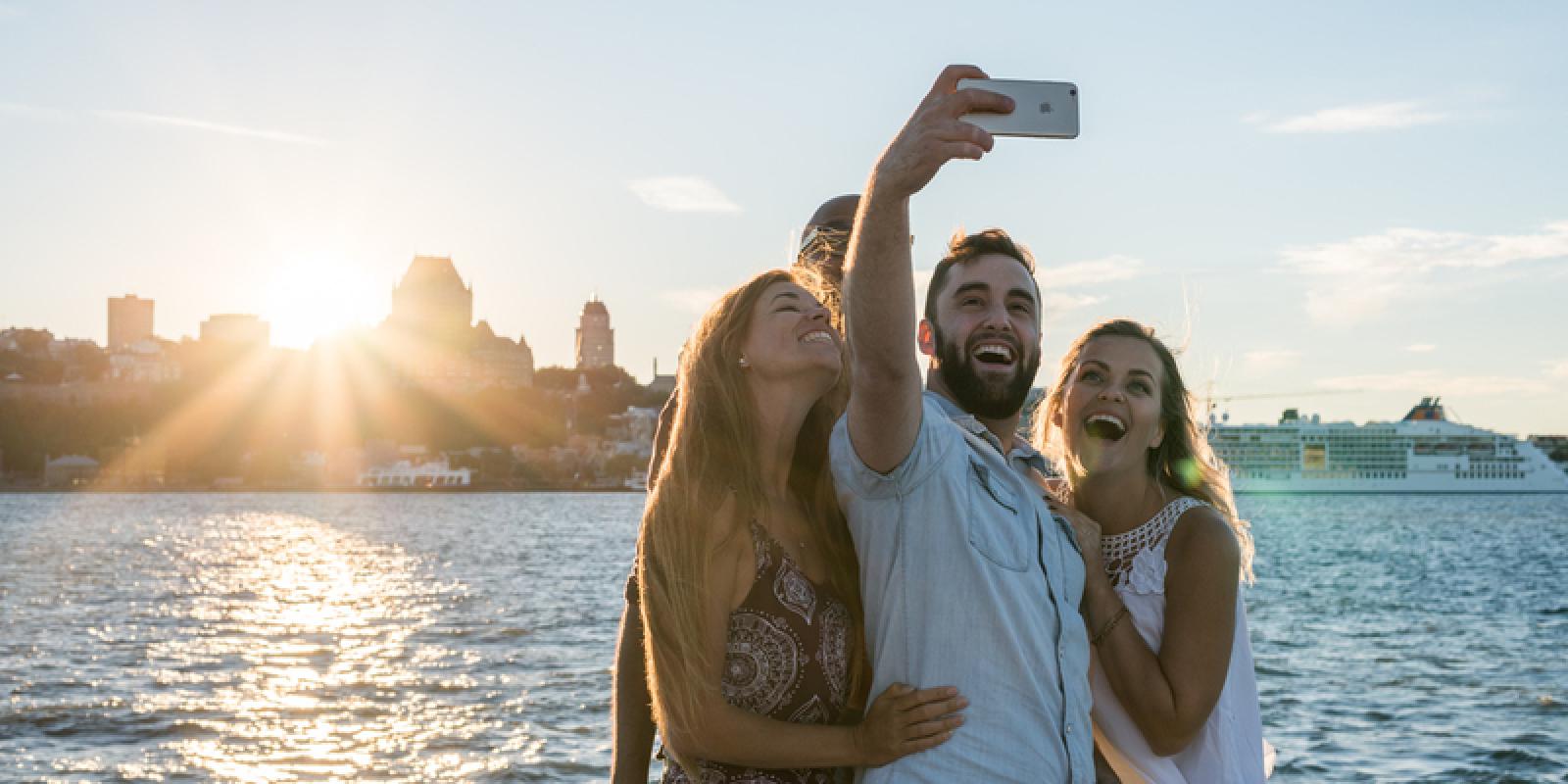 4 personnes qui prennent une photo selfie devant un panorama de Québec