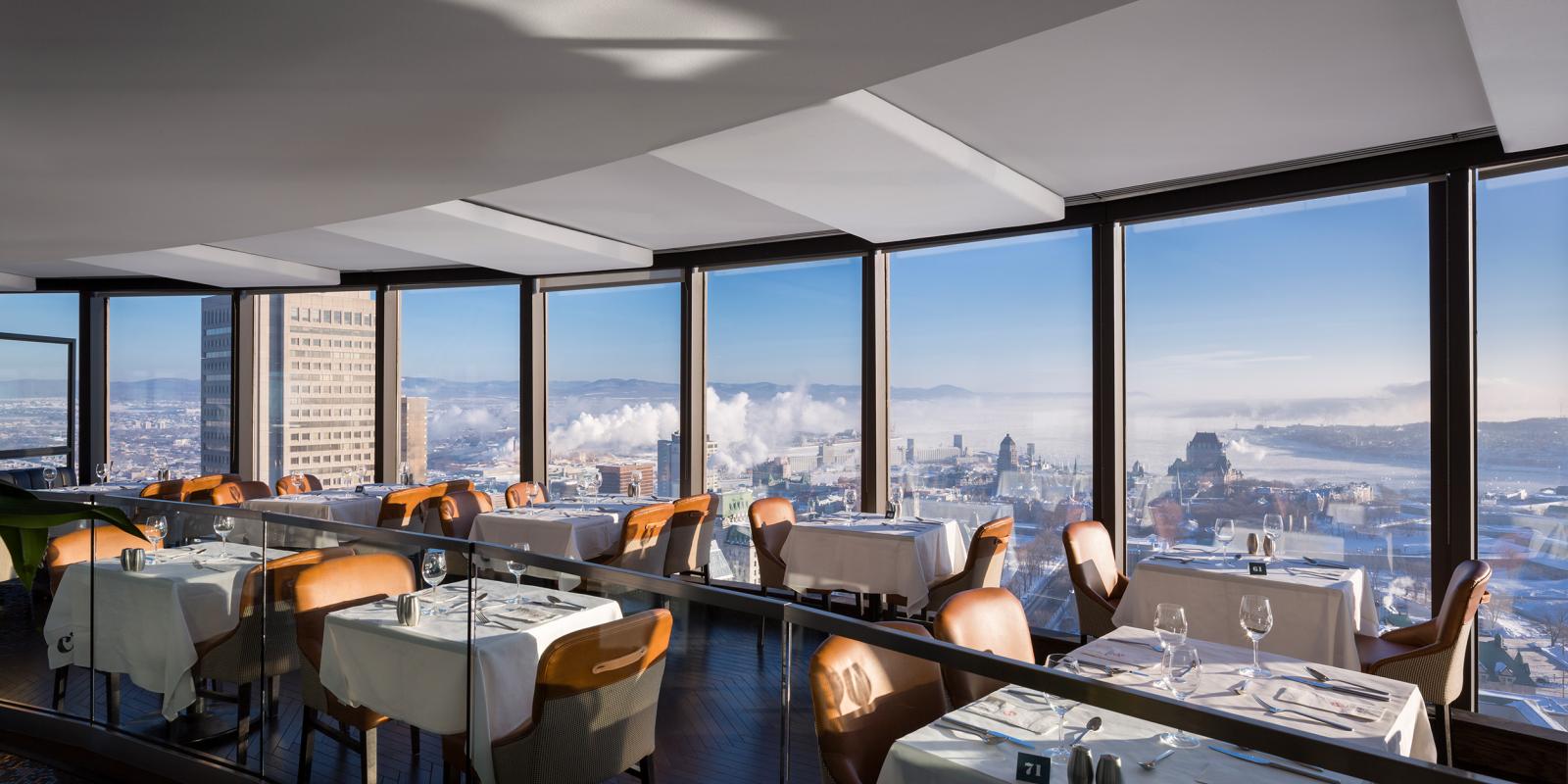 Dining room at Ciel! Bistro-bar with floor-to-ceiling windows overlooking Old Québec, Château Frontenac, and the St. Lawrence River.