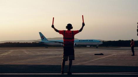 A member of staff at Quebec city airport guiding a plane for take off
