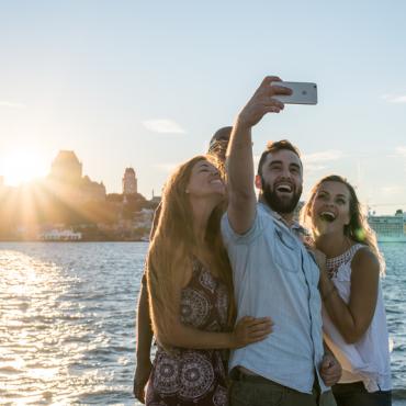 4 personnes qui prennent une photo selfie devant un panorama de Québec