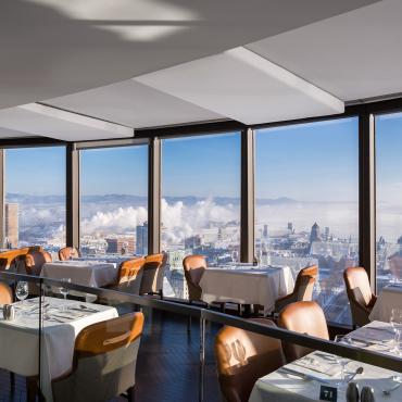 Dining room at Ciel! Bistro-bar with floor-to-ceiling windows overlooking Old Québec, Château Frontenac, and the St. Lawrence River.